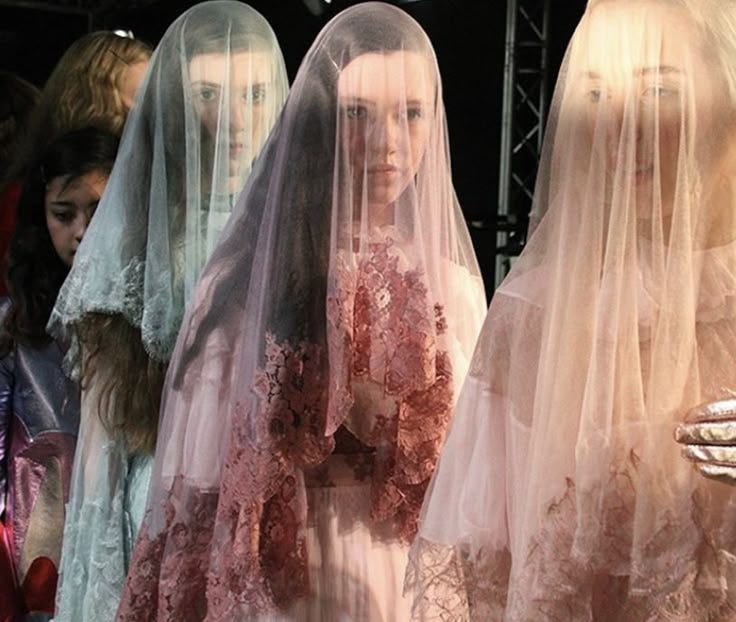 This may contain: several mannequins with veils on display at a fashion show