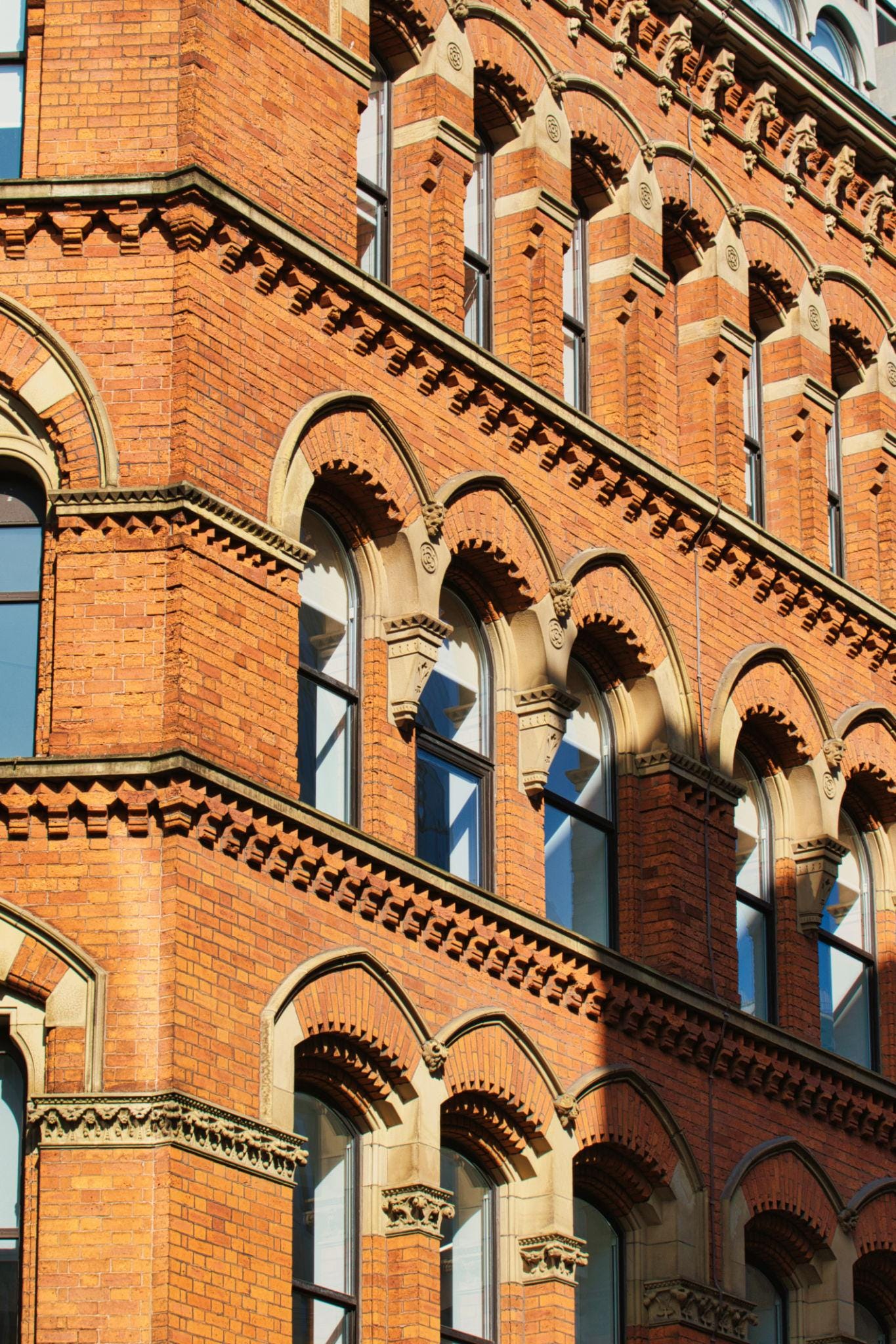 Brick Building Facade with Arched Windows in Manchester, UK. Brick Building Facade with Arched Windows in Manchester, UK.