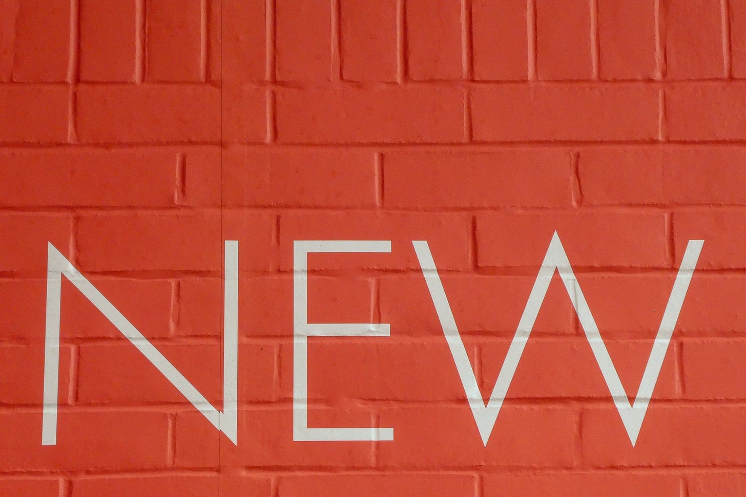"New" painted on a brick wall