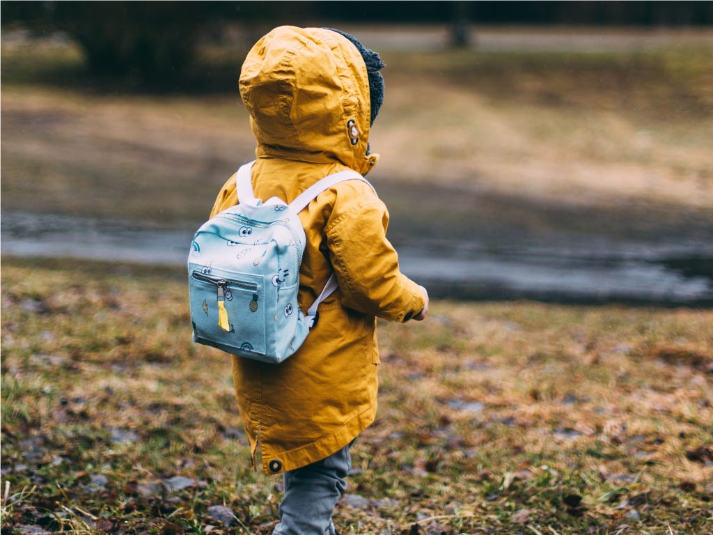 A young child in a yellow coat and a backpack stands with their back to the camera. Photo by Daiga Ellaby on Unsplash A young child in a yellow coat and a backpack stands with their back to the camera. Photo by Daiga Ellaby on Unsplash