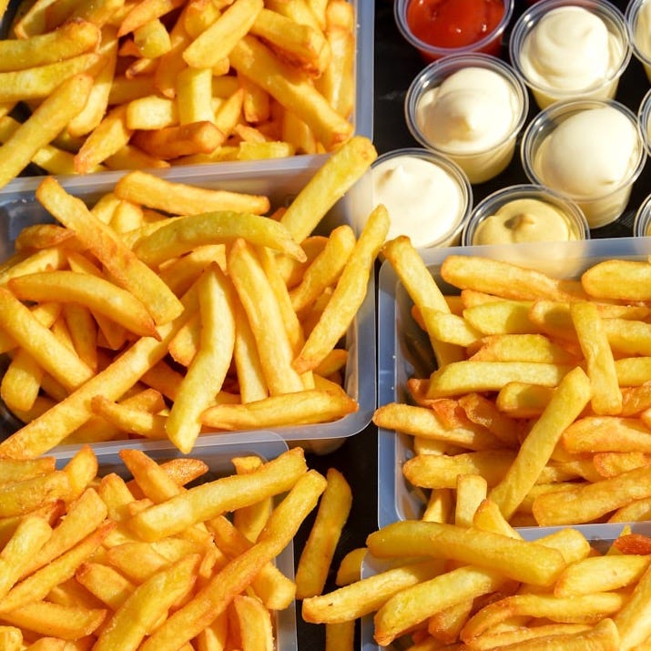 a tray of french fries with dips and condiments