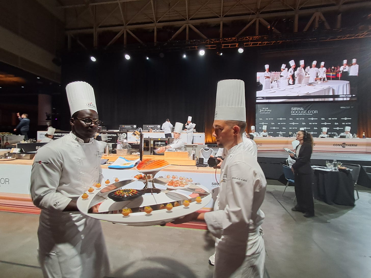 Chefs lending a hand: Chef Serigne Mbaye, of Dakar Nola, and an unidentified chef carry a presentation to the jury