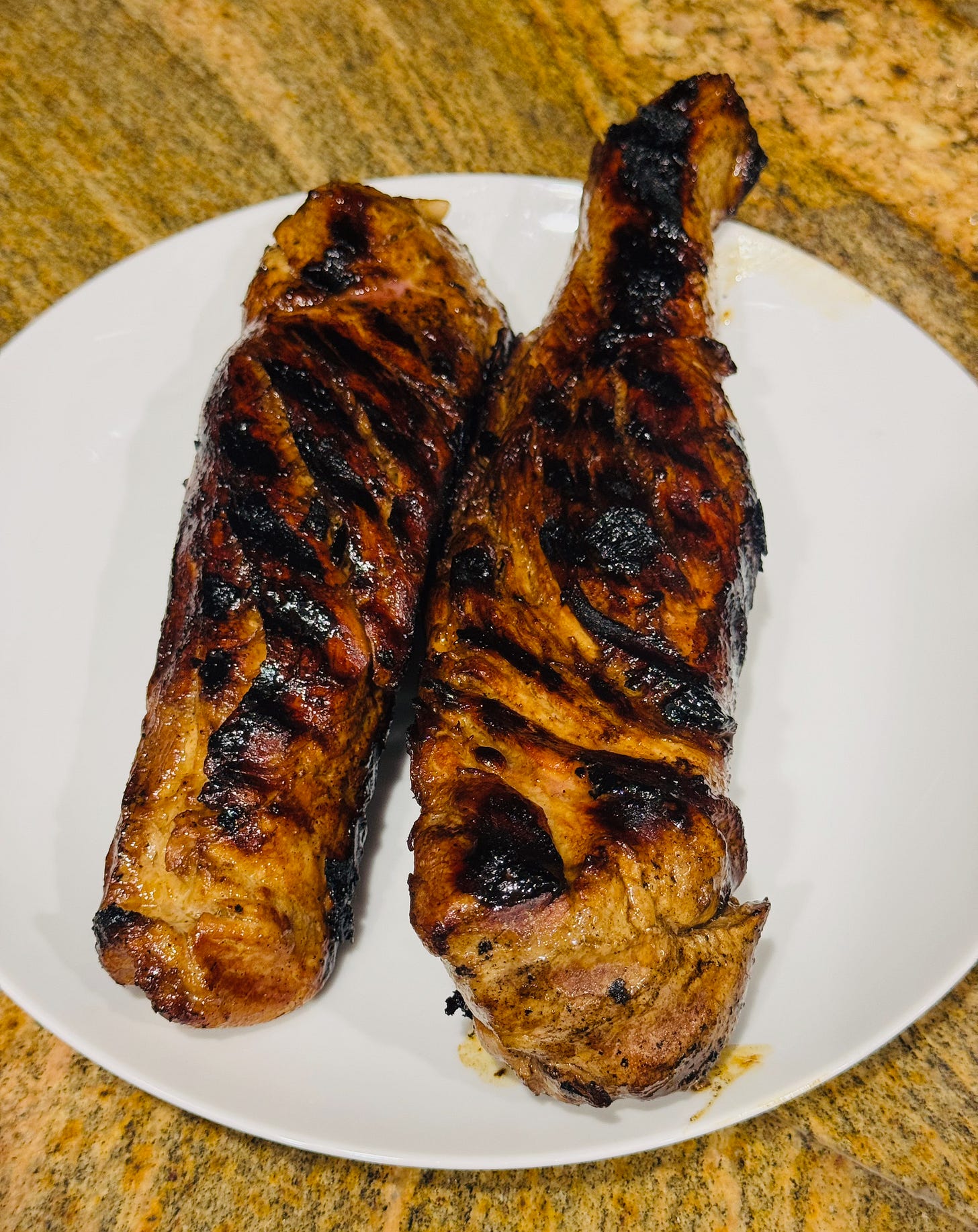  Two grilled pork tenderloins charred and caramelized in a grill pan — Doug's Easter recipe at The Dinner Bell Hearth