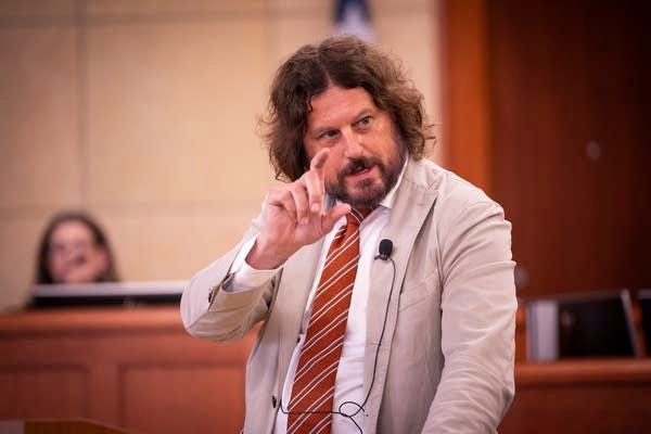 A defense attorney talks at a microphone A defense attorney talks at a microphone