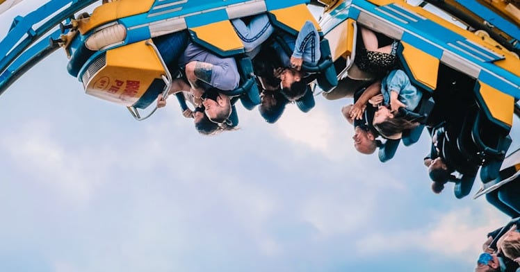 people riding roller coaster during daytime