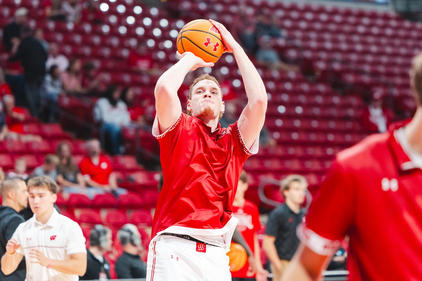 Wisconsin badgers men's basketball forward Austin Rapp attempts a jumpshot while wearing warmup gear