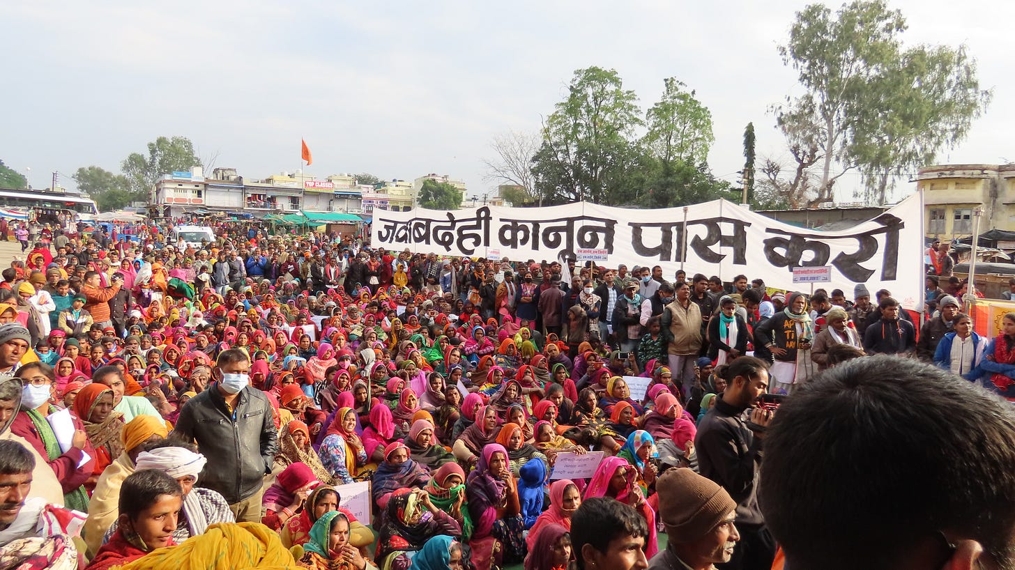 A large group of people in a procession with a banner that says- "Pass the Jawabdehi Bill" in Hindi