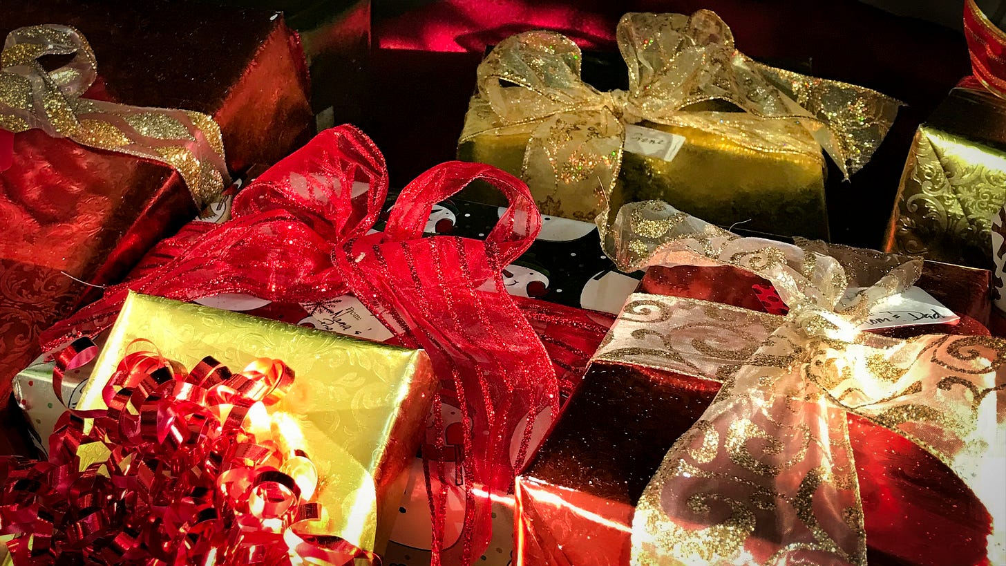 packages wrapped in red and gold paper with gold and red glittery bows