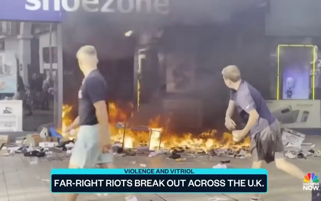 video screenshot of two white men with buzz cuts in front of a burning shoe store; one has just hurled a brick at the store video screenshot of two white men with buzz cuts in front of a burning shoe store; one has just hurled a brick at the store