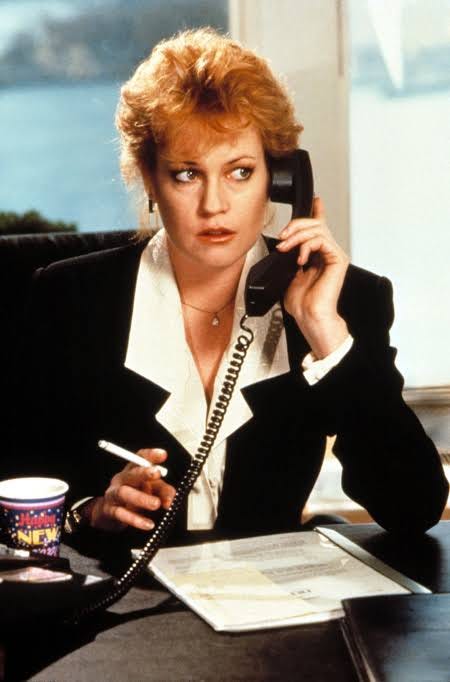 A high-flying career woman on the move, holding a briefcase and walking confidently through a busy environment, capturing the iconic 1980s corporate travel aesthetic. A high-flying career woman on the move, holding a briefcase and walking confidently through a busy environment, capturing the iconic 1980s corporate travel aesthetic.