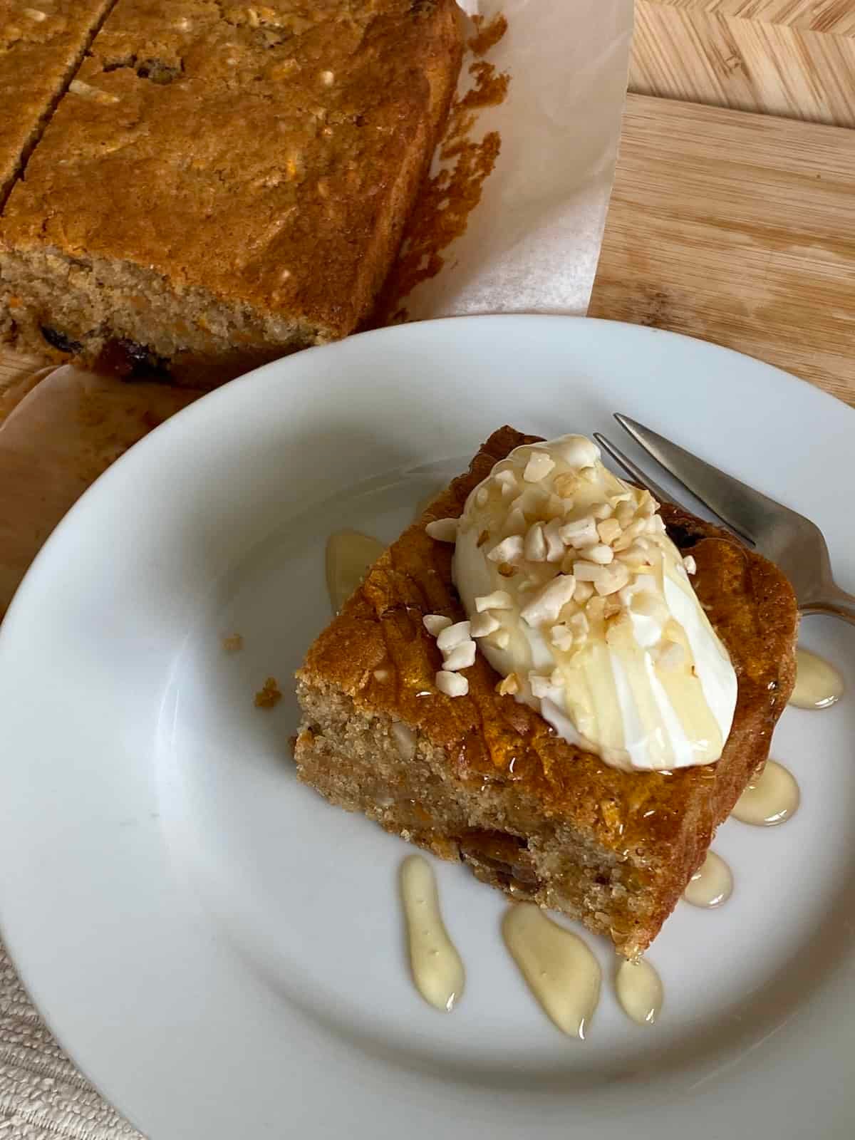 Slice of Carrot Cake Traybake topped with yogurt, honey and nuts. Slice of Carrot Cake Traybake topped with yogurt, honey and nuts.