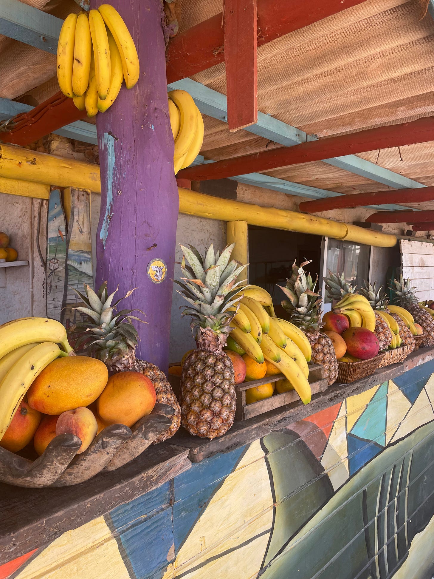 a juice store with fresh pineapples, bananas, and mangos decorating the front it a juice store with fresh pineapples, bananas, and mangos decorating the front it