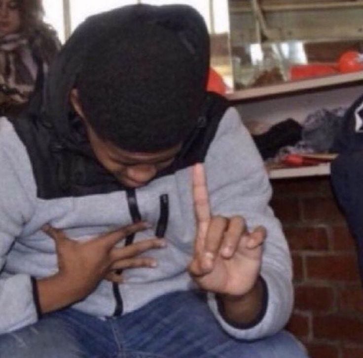 This may contain: a man sitting down with his hand on his chest