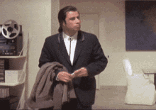 a man in a suit and tie stands in a room a man in a suit and tie stands in a room