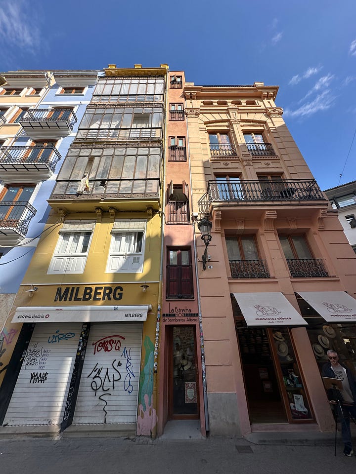 left: "La Estrecha" (The Narrow One), famous as the skinniest building in Valencia; right: live painting session nearby - they're all professionals!