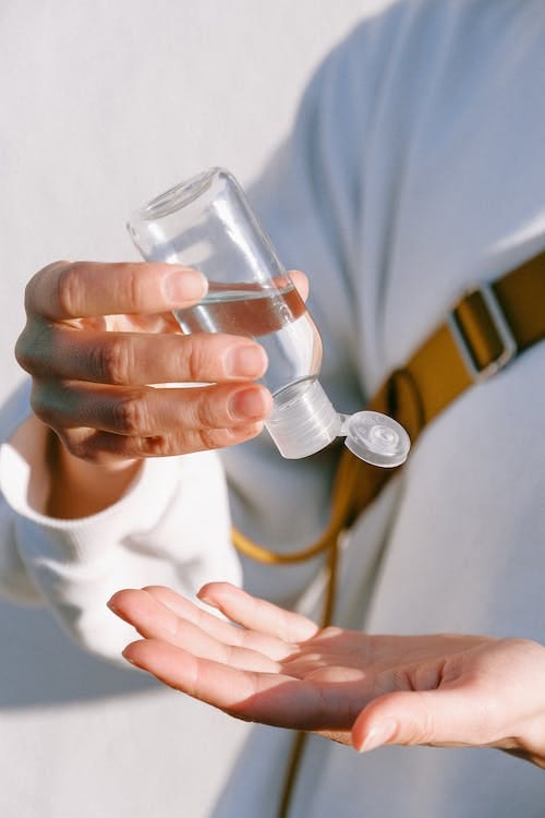 Free Person in White Long Sleeve Shirt Holding Clear Bottle Stock Photo