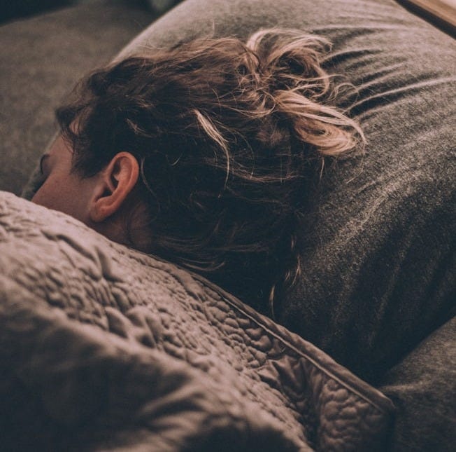woman sleeping on bed under blankets woman sleeping on bed under blankets