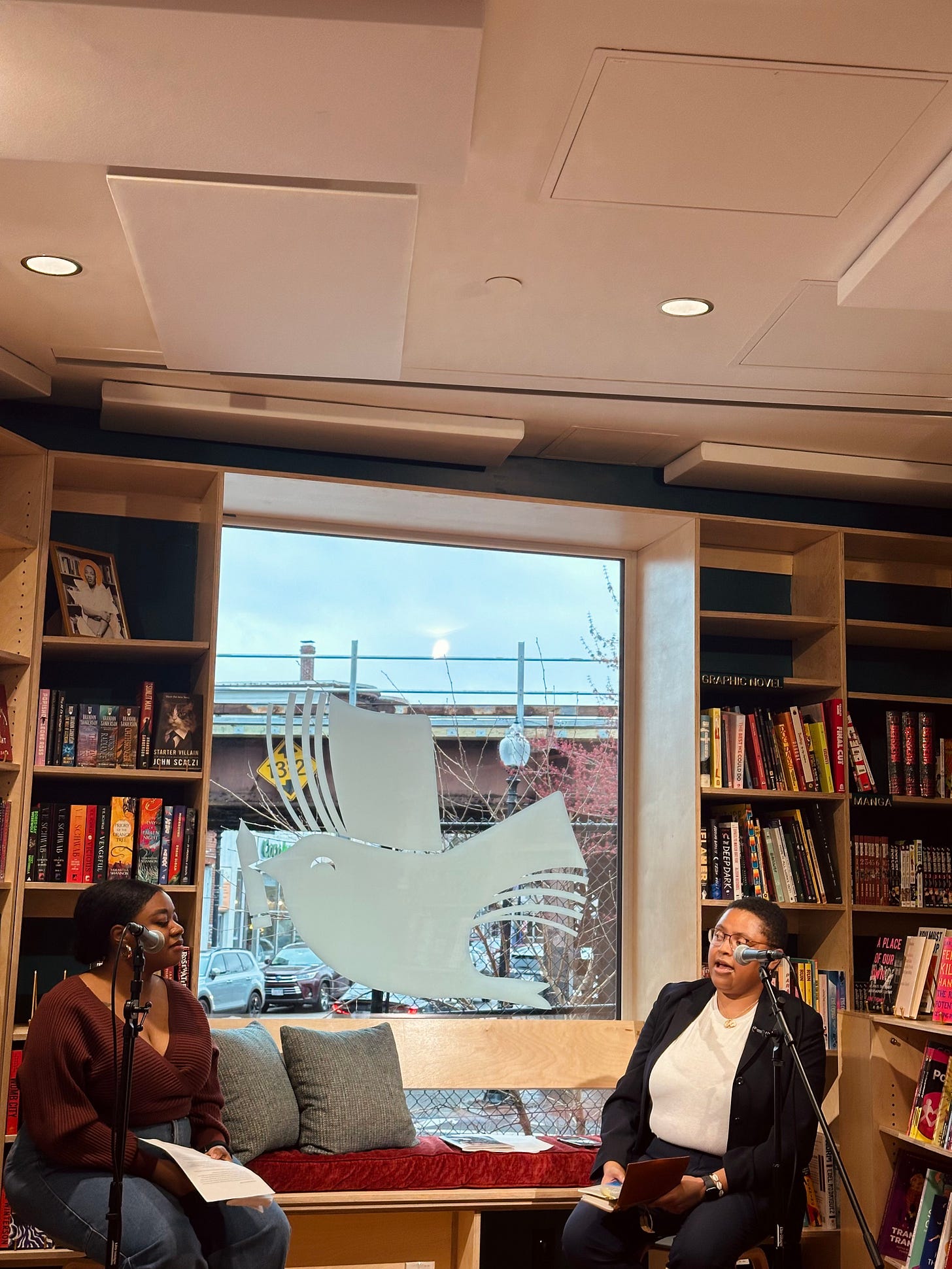 Tatiana (left) and Sarah Kersey (right) sitting in front of two microphones looking at each other mid-conversation