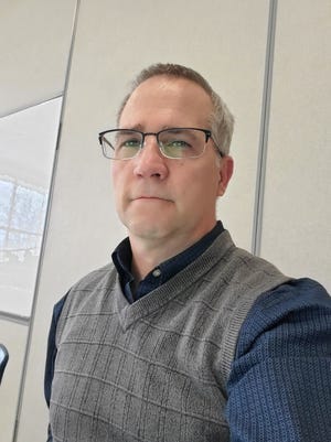 David Reichenberger, a beloved teacher at Appleton East who died unexpectedly last week, poses in one of his signature sweater vests.