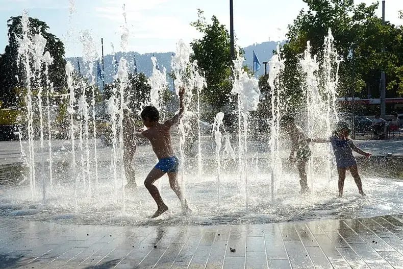 Photo of children playing in the street fountain near lake Zurich