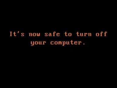 Orange text on black background reading "It's now safe to turn off your computer." Orange text on black background reading "It's now safe to turn off your computer."