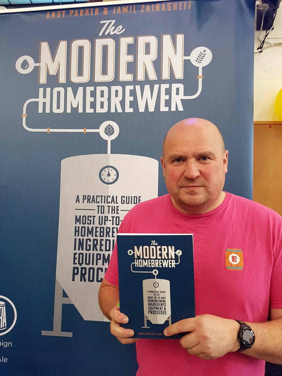 Elusive Brewing owner Andy Parker standing with his book The Modern Homebrewer