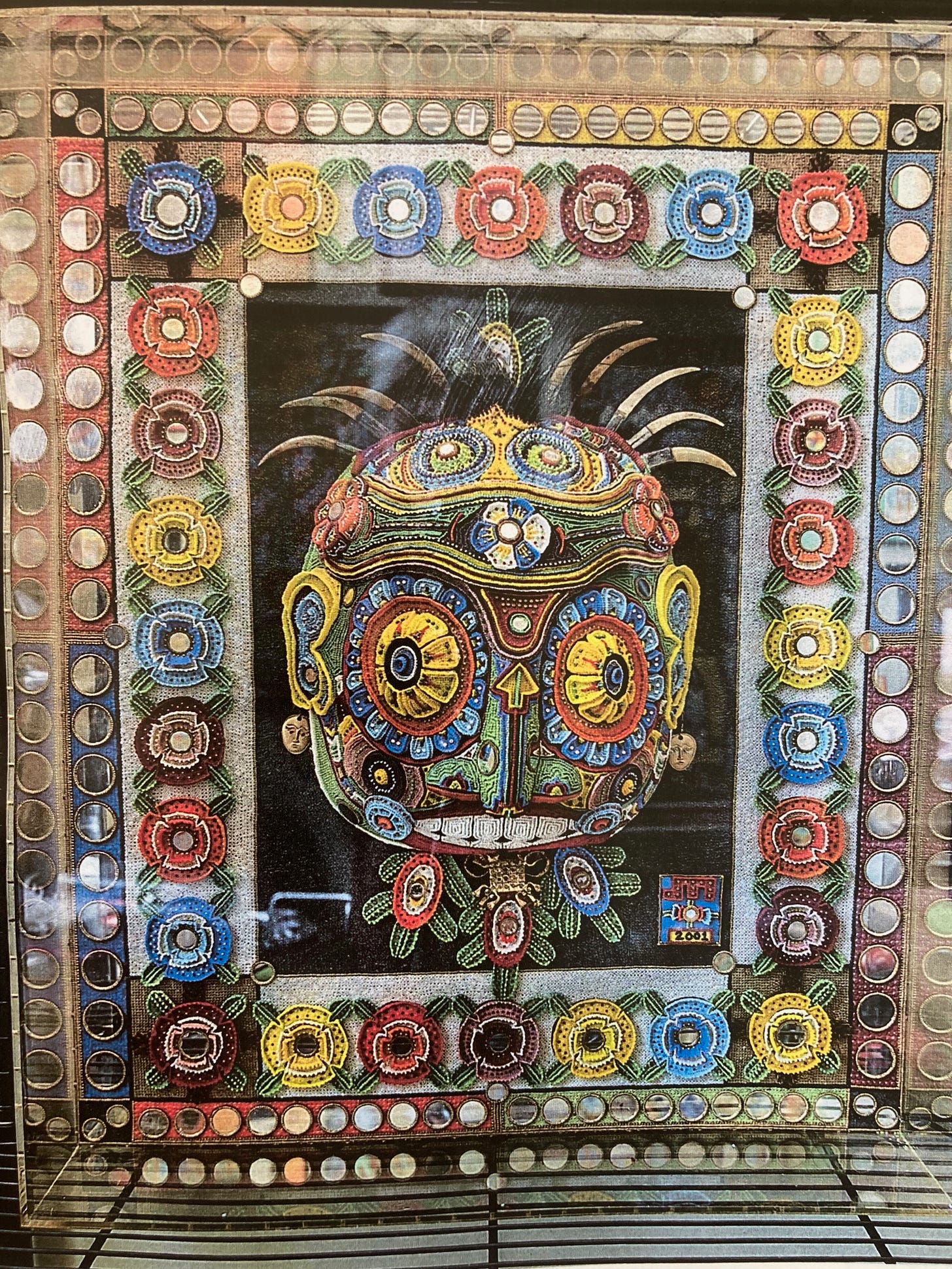 A wildly colorful artwork. At its center is the figure of a head, with all sorts of hallucinogenic elements. A wildly colorful artwork. At its center is the figure of a head, with all sorts of hallucinogenic elements.