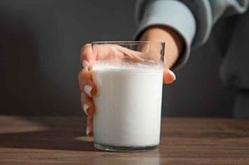 A hand holding a glass of milk

AI-generated content may be incorrect.