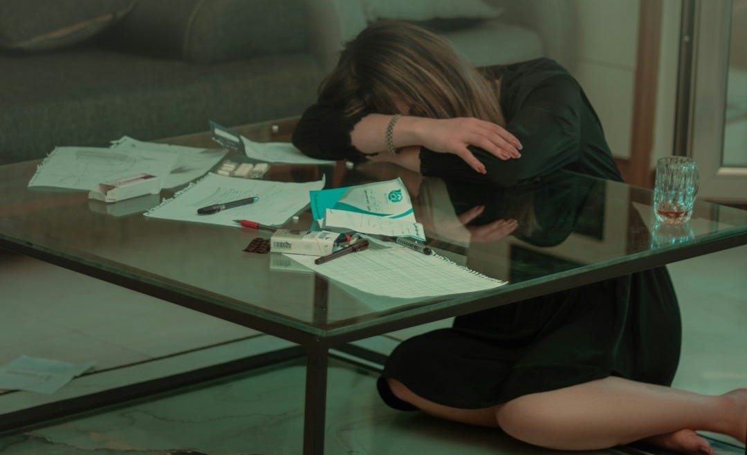 a woman sitting on the floor in front of a glass table