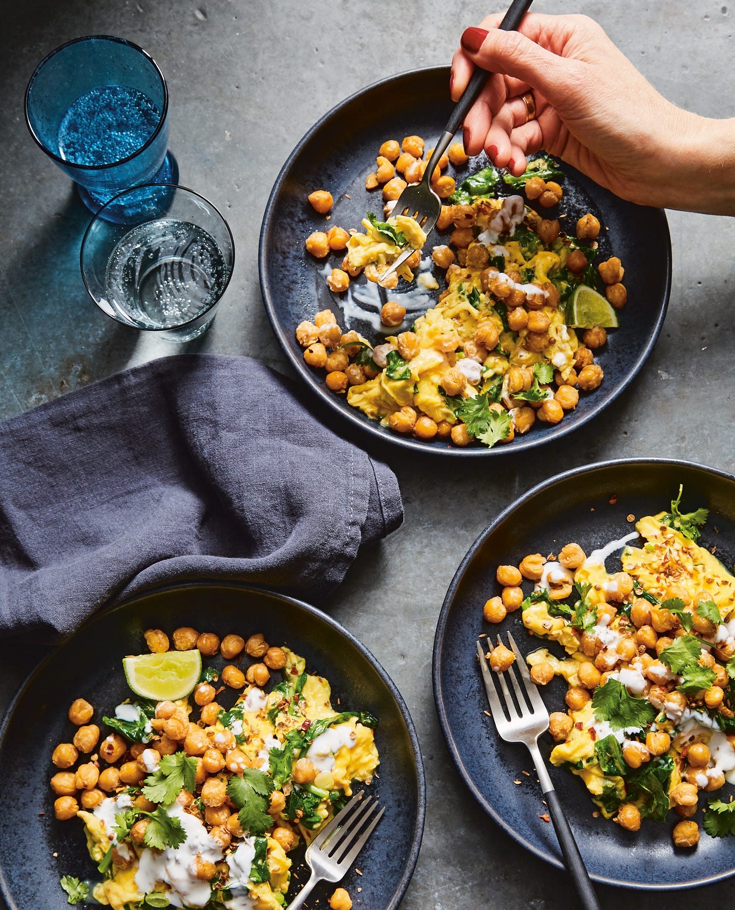 Three plates of crispy chickpeas with scrambled eggs and herbs.