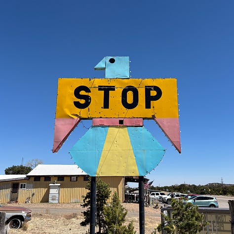 a decrepit gas station, vintage advertising sign and old car