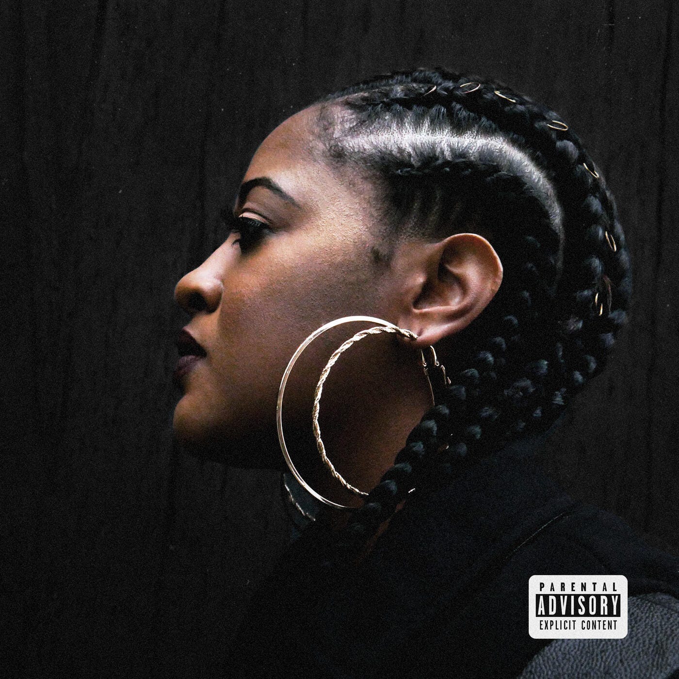 Cover art of the album "Eve" by Rapsody. She is seen in profile looking to the left. She has cornrow plaited Afro hair with gold hoops interlaced at intervals. She is also wearing oversized gold hoop earrings.