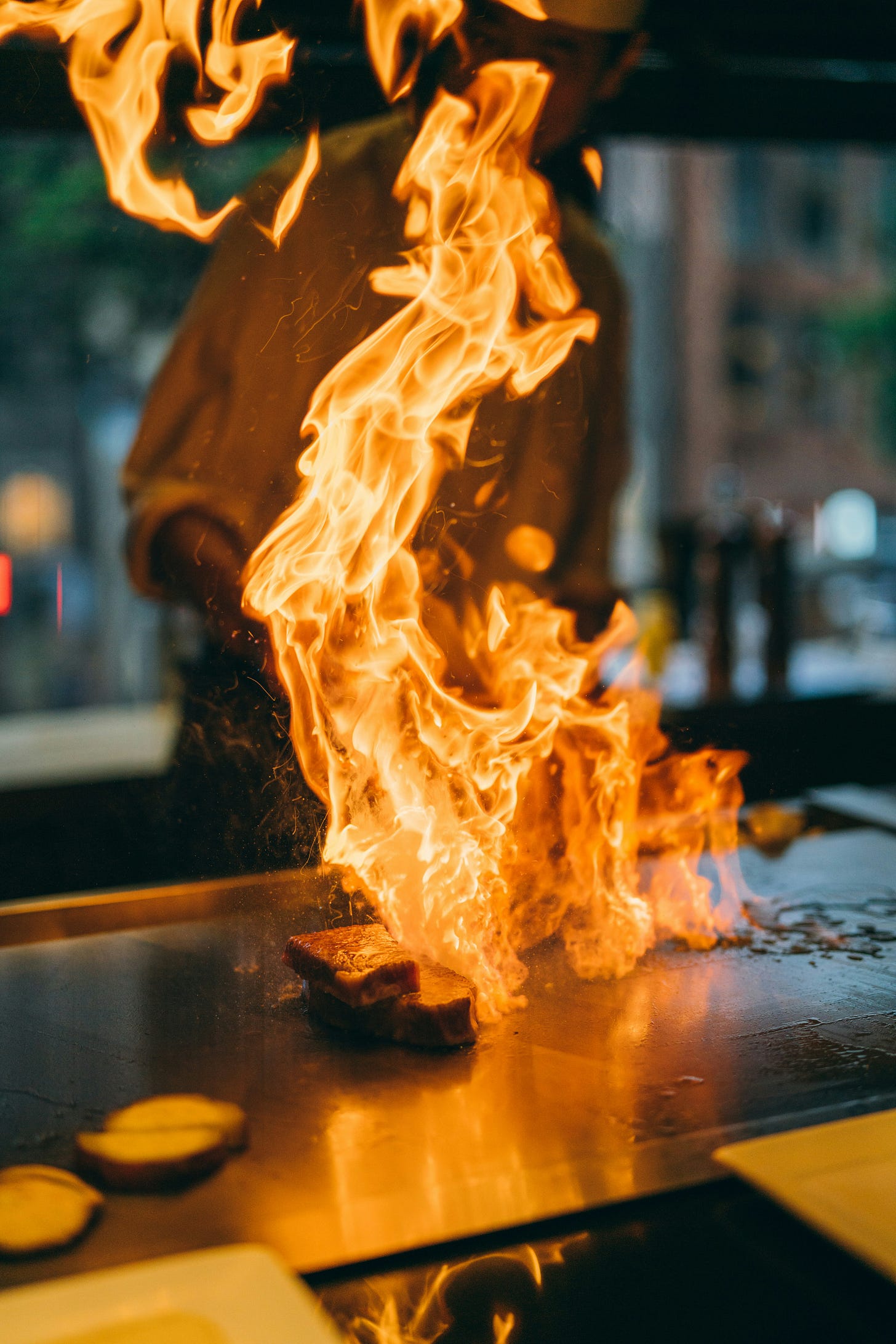 A fire on a grill at a steakhouse