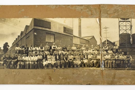 A sepia photograph of workers outside a wool mill