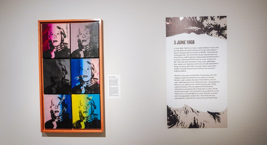 Andy Warhol's strangulation screen print series next to a label on a white wall Andy Warhol's strangulation screen print series next to a label on a white wall