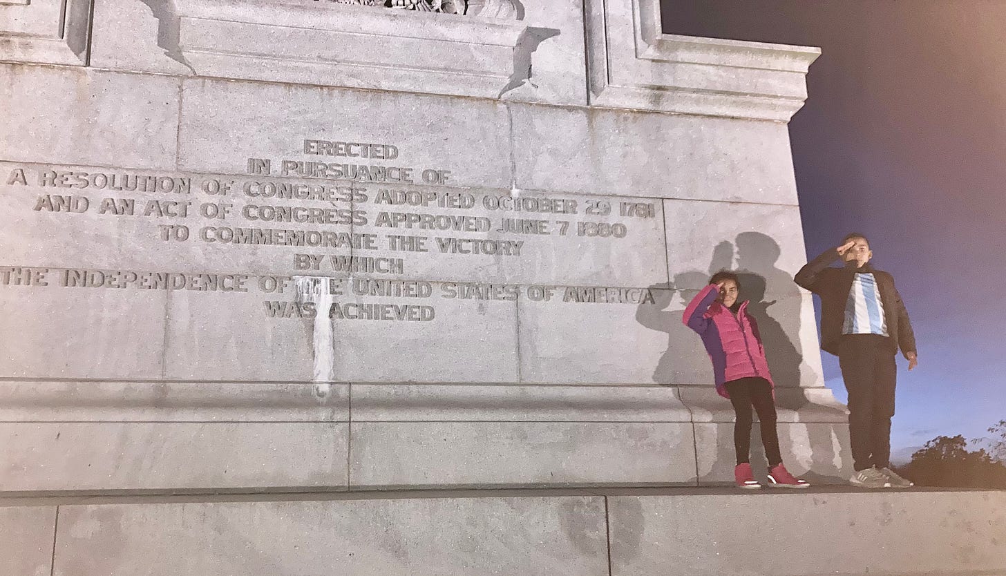 Some of the Maurer children saluting in front of the Yorktown monument inscription commemorating the American victory in 1781, circa 2022