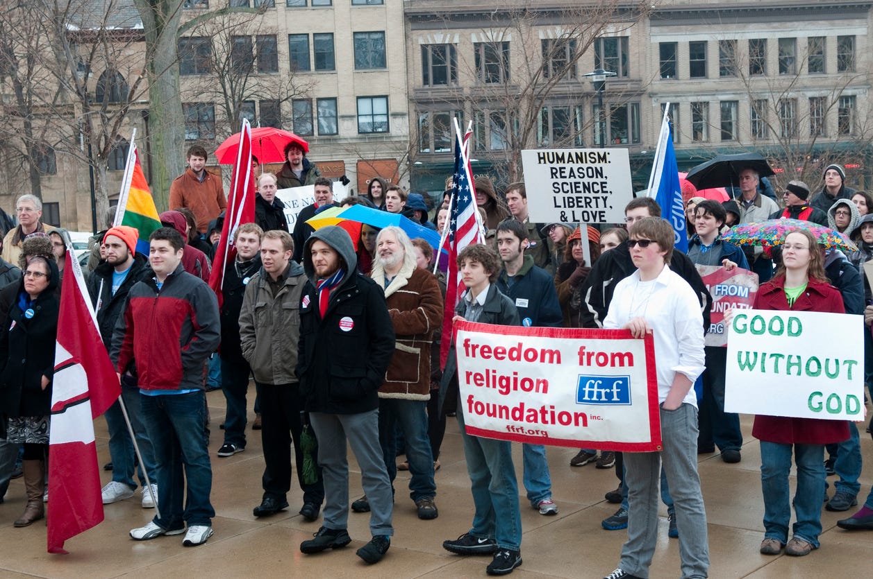 Madison, Wis. USA- March 9, 2013: Attendees from the University Wisconsin-Madison's Freethought Festival hold a rally for atheism and the separation of church and state outside the Wisconsin State Capitol. Madison, Wis. USA- March 9, 2013: Attendees from the University Wisconsin-Madison's Freethought Festival hold a rally for atheism and the separation of church and state outside the Wisconsin State Capitol.