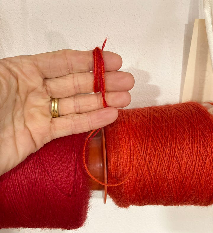 Two photographs showing firstly a wall with cones of coloured wool hung on poles and secondly a hand with two shades of red wool blended together ready for knitting.