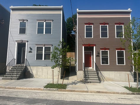 Exterior photos of new townhouses from the street and from the backyard. Several interior photos of a first floor with an open layout.
