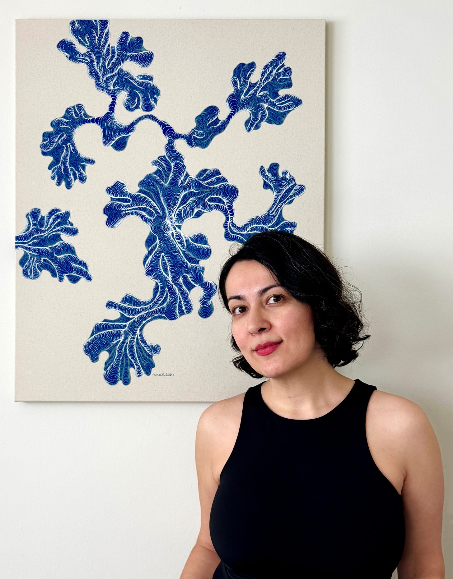 Artist Moti Tavassoli standing with her artwork.