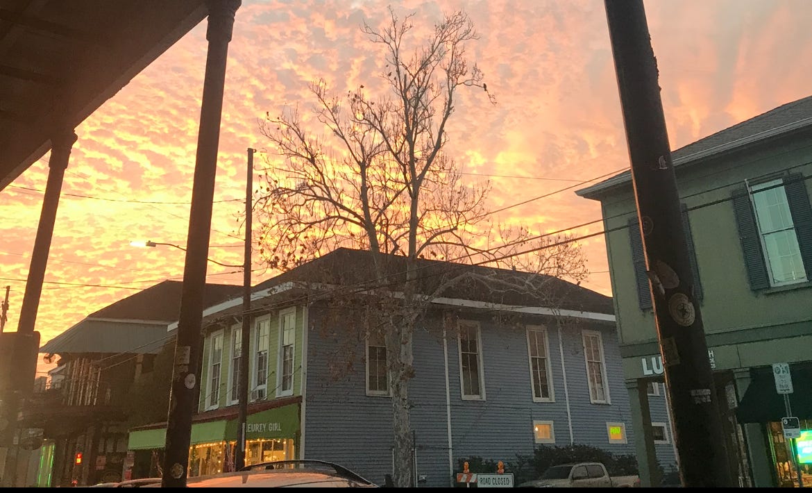 a very orange sunset over my former neighborhood, including a "road closed" sign on my former street, taken shortly after the procedure in the essay