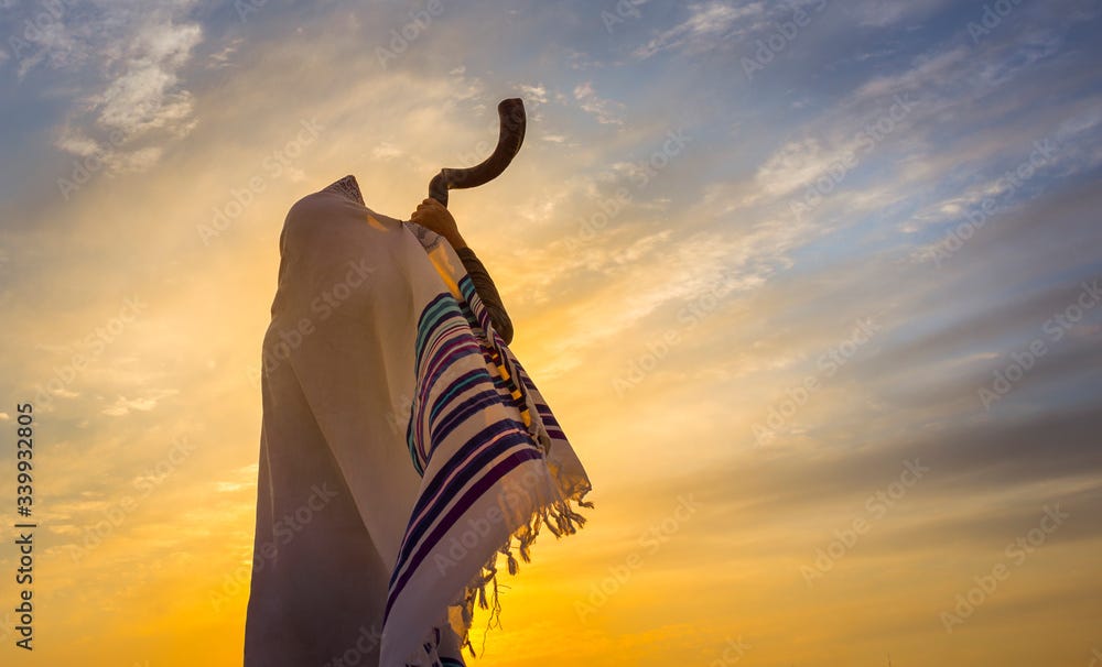 Blowing the Shofar - man in a tallith, Jewish prayer shawl is blowing the shofar ram's horn