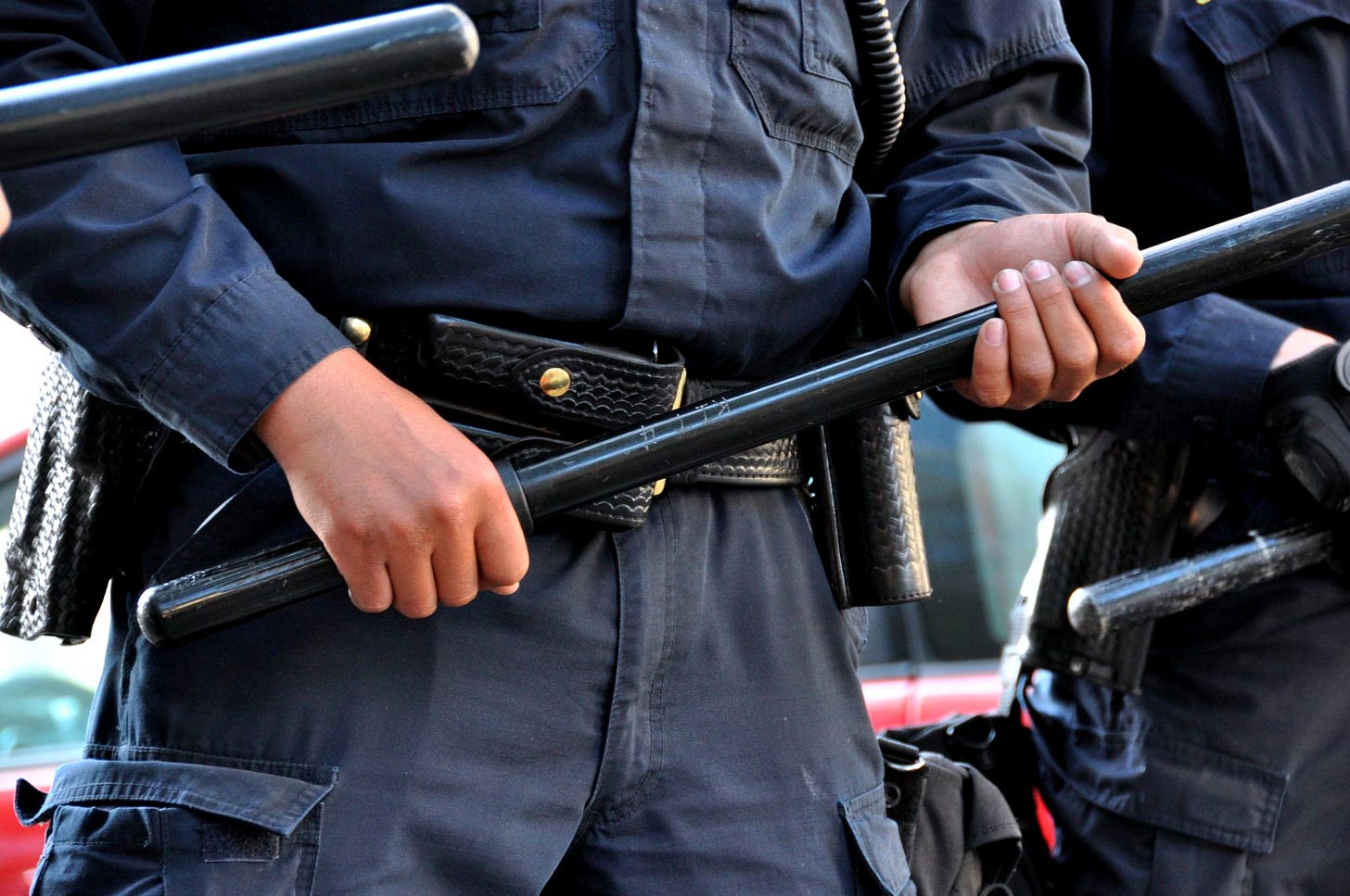 Oakland police officer holding a baton on July 8, 2010. City officials have raised concerns that allowing the Oakland Police Commission to manage its own staffing study could create a conflict of interest. (Image source: Jonathan McIntosh / Creative Commons)