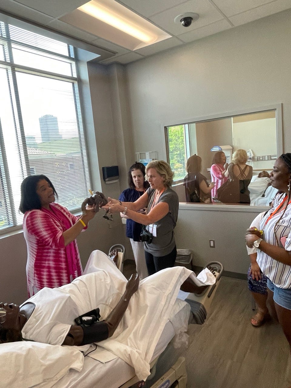 catching the baby in Labor & Delivery! The reflection in the window behind me was one of two rooms where students and faculty observe care. State-of-the-art mannequins provide students with an accurate and realistic critical care experience.