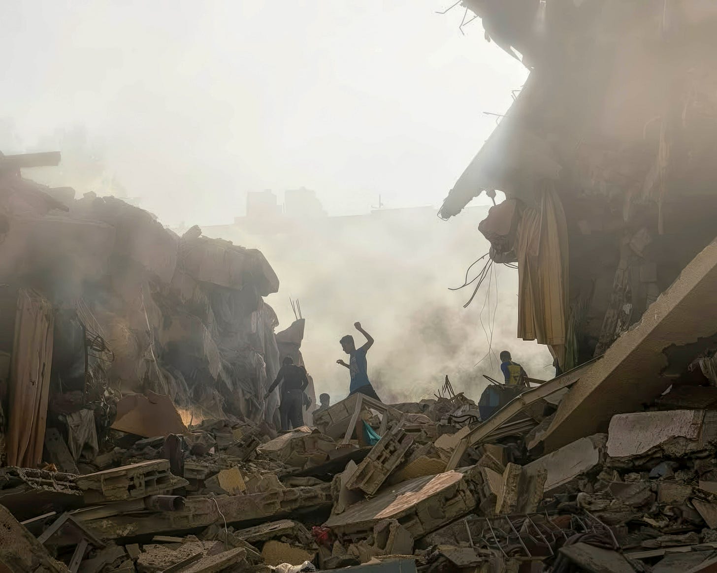 Palestinian children above the rubble of Al Zahra Towers after Israeli airstrikes demolished the area.