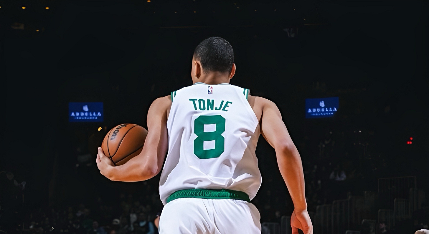 Boston Celtics guard John Tonje dribbles the ball up the court during a game.