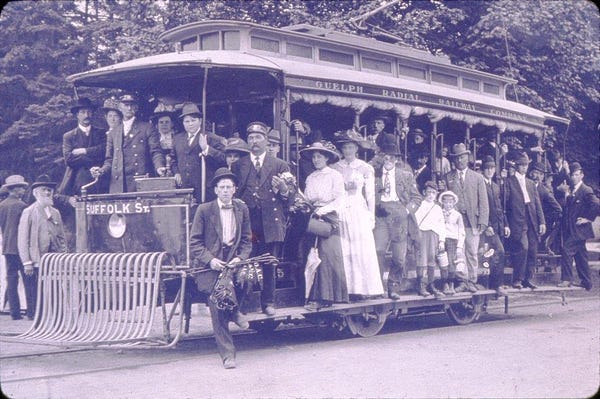 Black and white slide of people crowded onto a Guelph Radial Railway car to go to an exhibition of the Ontario Agricultural College. There are at least thirty people visible in the photograph; men, women and children.