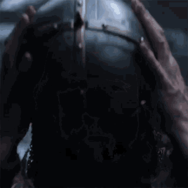 a close up of a person holding a helmet in their hands .