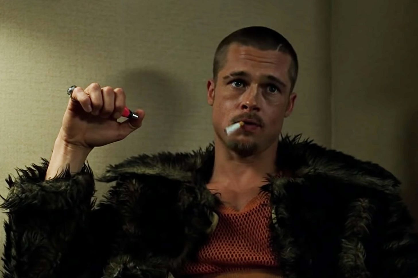 Brad Pitt holds a red lighter. His head is shaved and he's wearing a fur coat and a red mesh tank top. Still from "Fight Club" (1999)