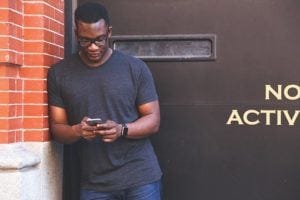 Young man of African descent looking at phone